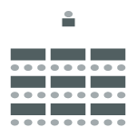 Rows of desks and chairs with one desk and chair at the front